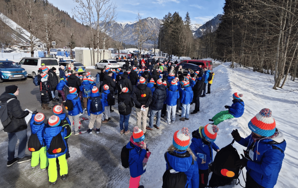 Kinder laufen als Gruppe zur Skiflug-Schanze. Dabei sieht man die von uns produzierten schwarzen Jutebeutel mit dem Mastercard Logo drauf.