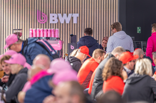 Zu sehen ist die Kaffeebar mit dem BWT Logo im Hintergrund, davor sitzen vielen Gäste.