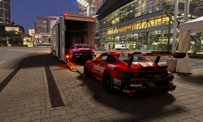2 DTM Porsche Fahrzeuge die gerade auf einem Messegelände eingeladen werden