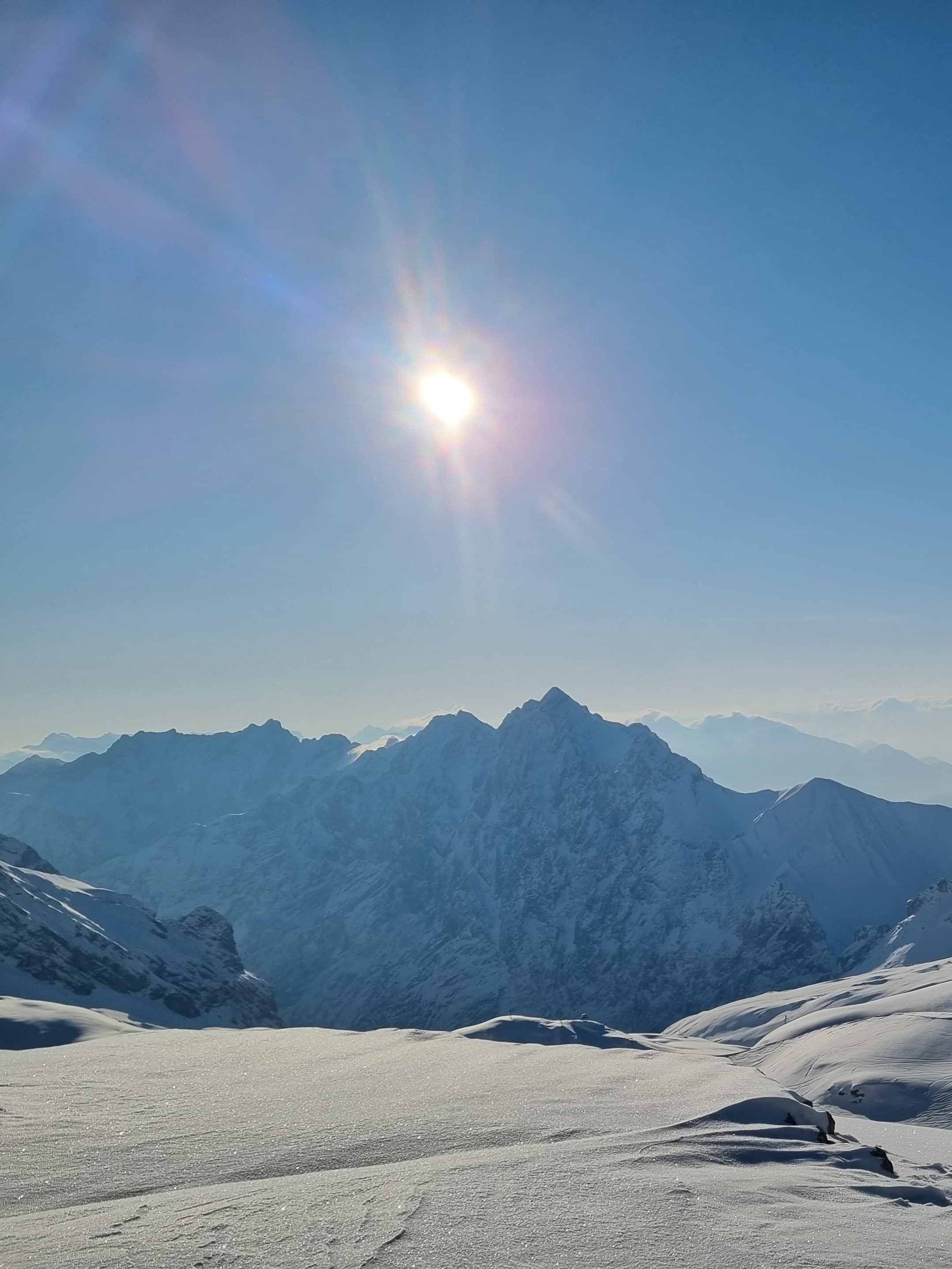 verschneite Berglandschaft und strahlende Sonne