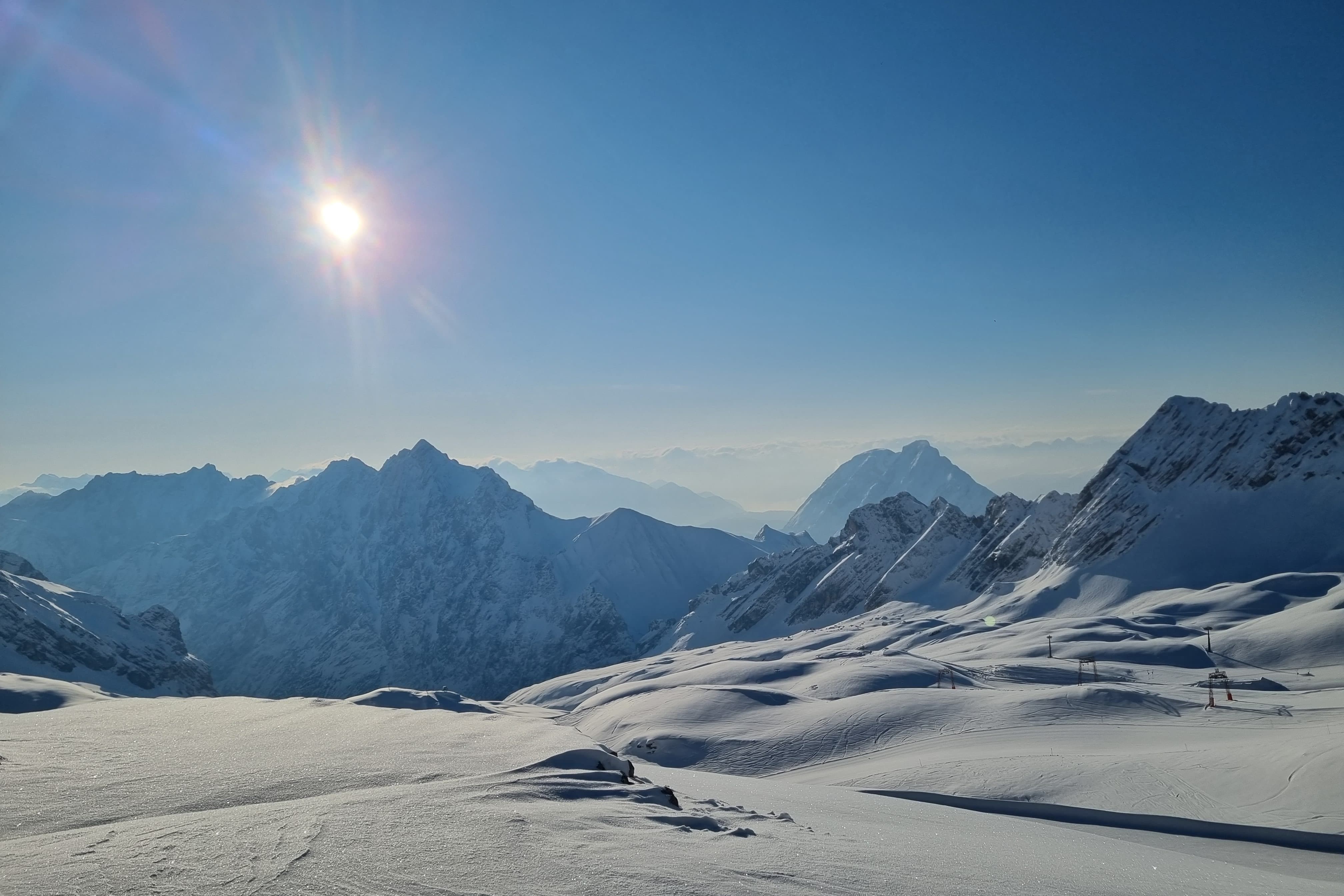 verschneite Berglandschaft und strahlende Sonne